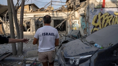 Israelis inspizieren die Trümmer eines Gebäudes in Tel Aviv, das am Wochenende von einer aus dem Gazastreifen abgefeuerten Rakete getroffen wurde. (Foto: Oded Balilty/AP/dpa)