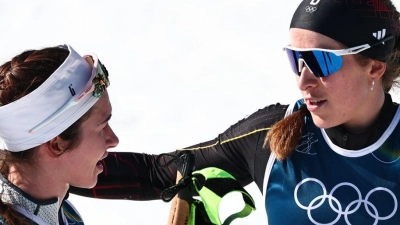 Darija Neprjajeva (l) nahm während des Olympia-Rennens versehentlich die Ski von Katharina Hennig Dotzler. (Foto: Daniel Karmann/dpa)