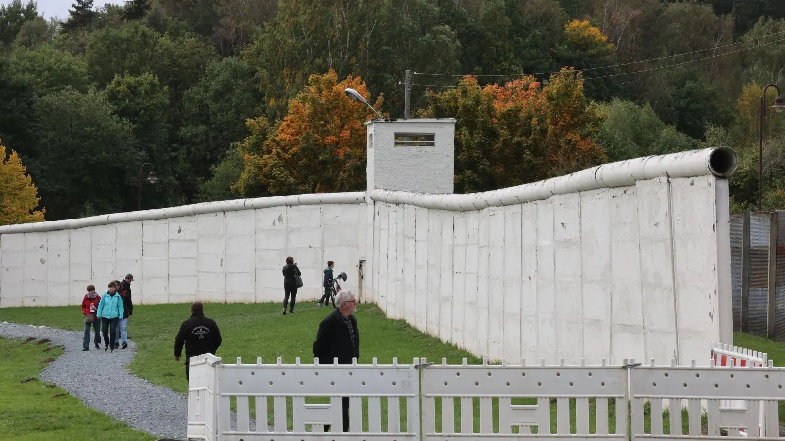 Besucher stehen vor einem Stück Grenzmauer der ehemaligen Staatsgerenze der DDR auf dem Gelände des Grenzmuseums am Rande des Deutschlandfest der CSU zum Tag der Deutschen Einheit. (Foto: Bodo Schackow/dpa)