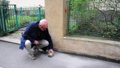 Gregory Tigrid hält den Stolperstein für seinen Vater Pavel Tigrid. In Prag erinnert vor dem Haus Kouřimská 5 ein neuer Stolperstein an den tschechischen Schriftsteller und Ex-Kulturminister Pavel Tigrid (1917-2003).  (Foto: Michael Heitmann/dpa)