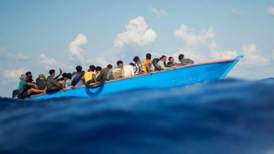 Migranten sitzen in einem Holzboot im Mittelmeer nahe der Insel Lampedusa: Die kleine Insel gehört seit Jahren zu den Brennpunkten illegaler Migration (Archivfoto). (Foto: Francisco Seco/AP/dpa)