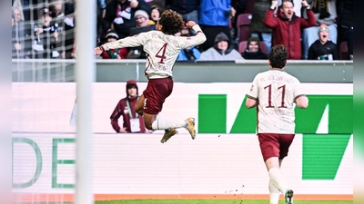 Han-Noah Massengo hebt nach seinem 1:0 jubelnd ab - zum Sieg reichte sein Kopfballtor für den FC Augsburg aber nicht.  (Foto: Harry Langer/dpa)