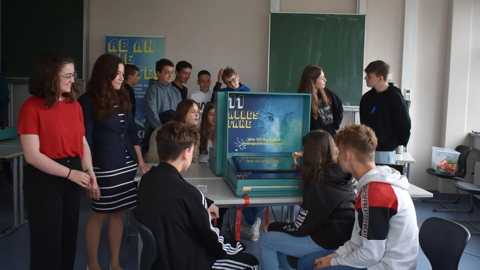 Christina Drebinger und Clelia Russolillo (links) sind ebenso wie die Schülerinnen und Schüler der Dietrich-Bonhoeffer-Realschule von der Ausstellung „Künstliche Intelligenz in der Kiste“ begeistert. (Foto: Ute Niephaus)
