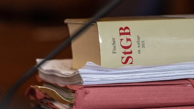 Das Strafgesetzbuch und Akten liegen in einem Gericht auf dem Tisch. (Foto: Swen Pförtner/dpa/Symbolbild)