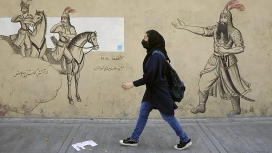 Ein Mädchen geht an einer Häuserfassade in Teheran entlang. (Foto: ---/dpa)