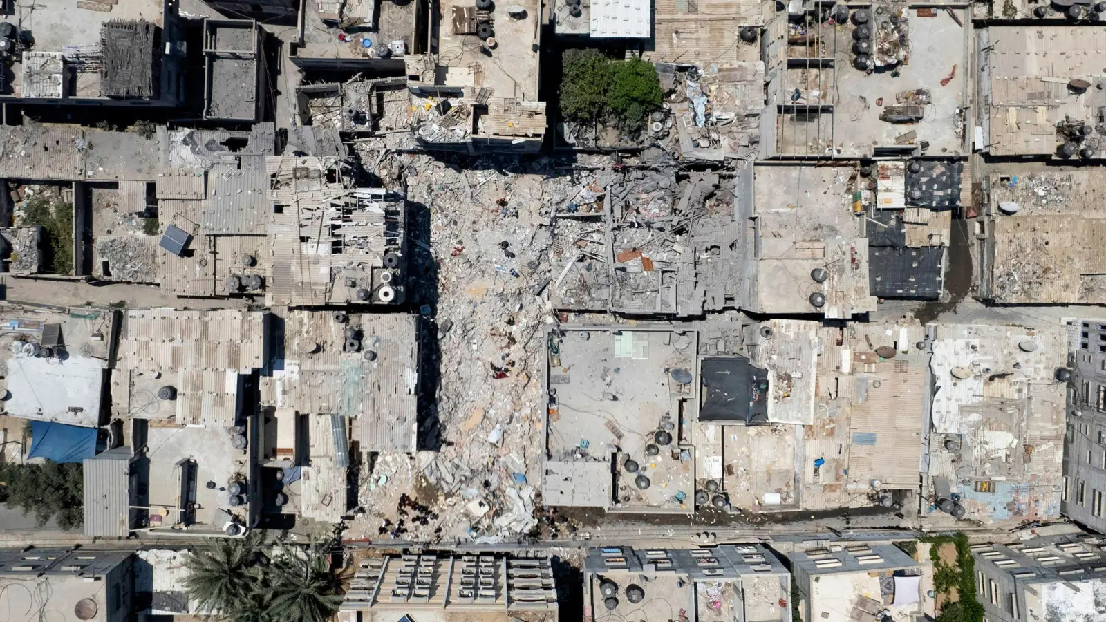 Palästinenser durchsuchen die Trümmer eines Gebäudes, in dem Khaled Mansour, ein führender Kämpfer des Islamischen Dschihad, am 07.08.22 bei einem israelischen Luftangriff getötet wurde. (Foto: Hatem Moussa/AP/dpa)