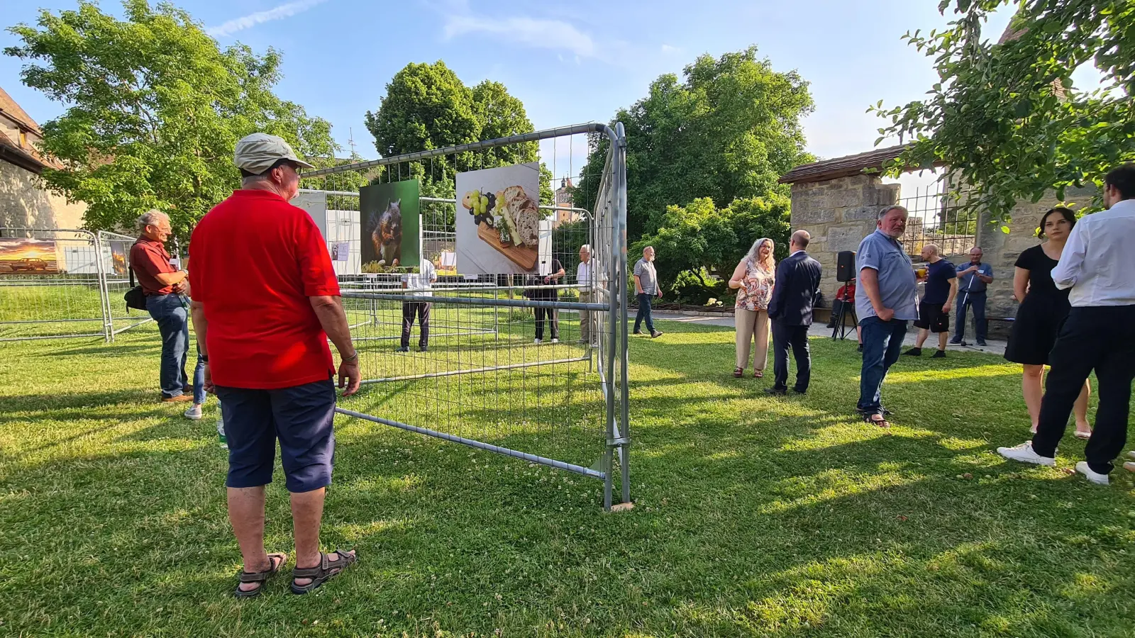 Eine Fotoausstellung im Freien ist nicht gerade alltäglich. Die ausgewählten Motive sind wetterfest und stabil an Bauzaunelementen angebracht. Das Foto entstand bei der Eröffnung. (Foto: Margit Schwandt)