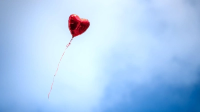 Ein herzförmiger Luftballon fliegt durch die Luft. (Foto: Sina Schuldt/dpa/Symbolbild)