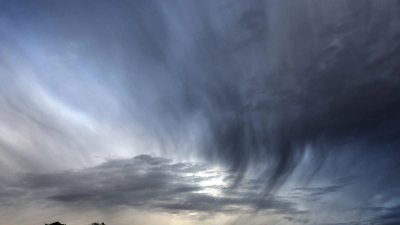 Regenwolken ziehen über eine Baumgruppe. (Foto: Karl-Josef Hildenbrand/dpa/Symbolbild)