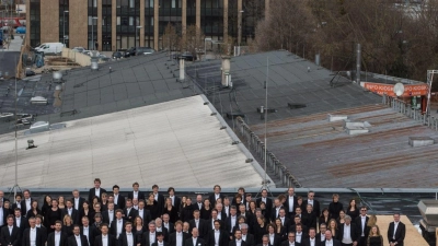 Die Musiker des Sinfonieorchesters des Bayerischen Rundfunks posieren für ein Gruppenfoto auf einem Dach an der Kultfabrik im Werksviertel. (Foto: Matthias Balk/dpa)