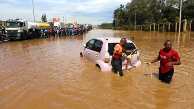 Menschen in Nairobi, die im Hochwasser ein Auto ziehen. (Foto: Joy Nabukewa/XinHua/dpa)