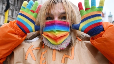 Eine Teilnehmerin trägt beim Münchner Ostermarsch Handschuhe und eine Mund-Nasen Schutz in Peace Farben. (Foto: Angelika Warmuth/dpa)