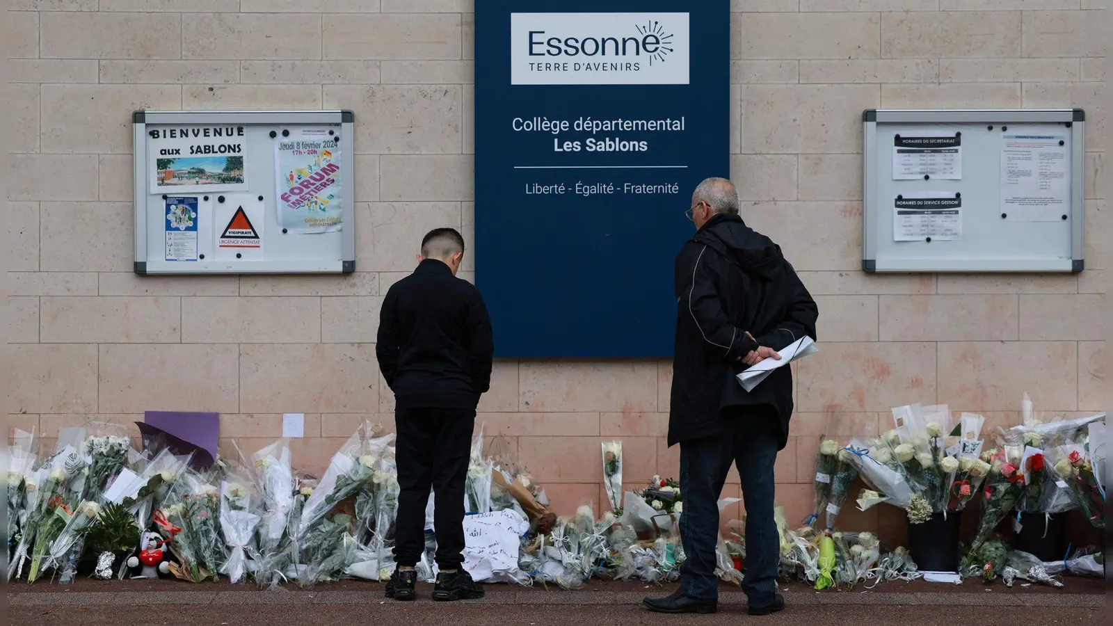 Blumen vor dem Eingang der Mittelschule Les Sablons in Viry-Chatillon nach dem gewaltsamen Tod eines 15-jährigen Schülers. (Foto: Emmanuel Dunand/AFP/dpa)