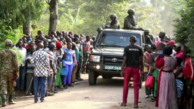 Ugandische Sicherheitskräfte fahren an einer Menschenmenge vorbei, die sich nach dem Angriff vor der Schule in Mpondwe versammelt hat (Videostandbild). (Foto: Uncredited/AP/dpa)
