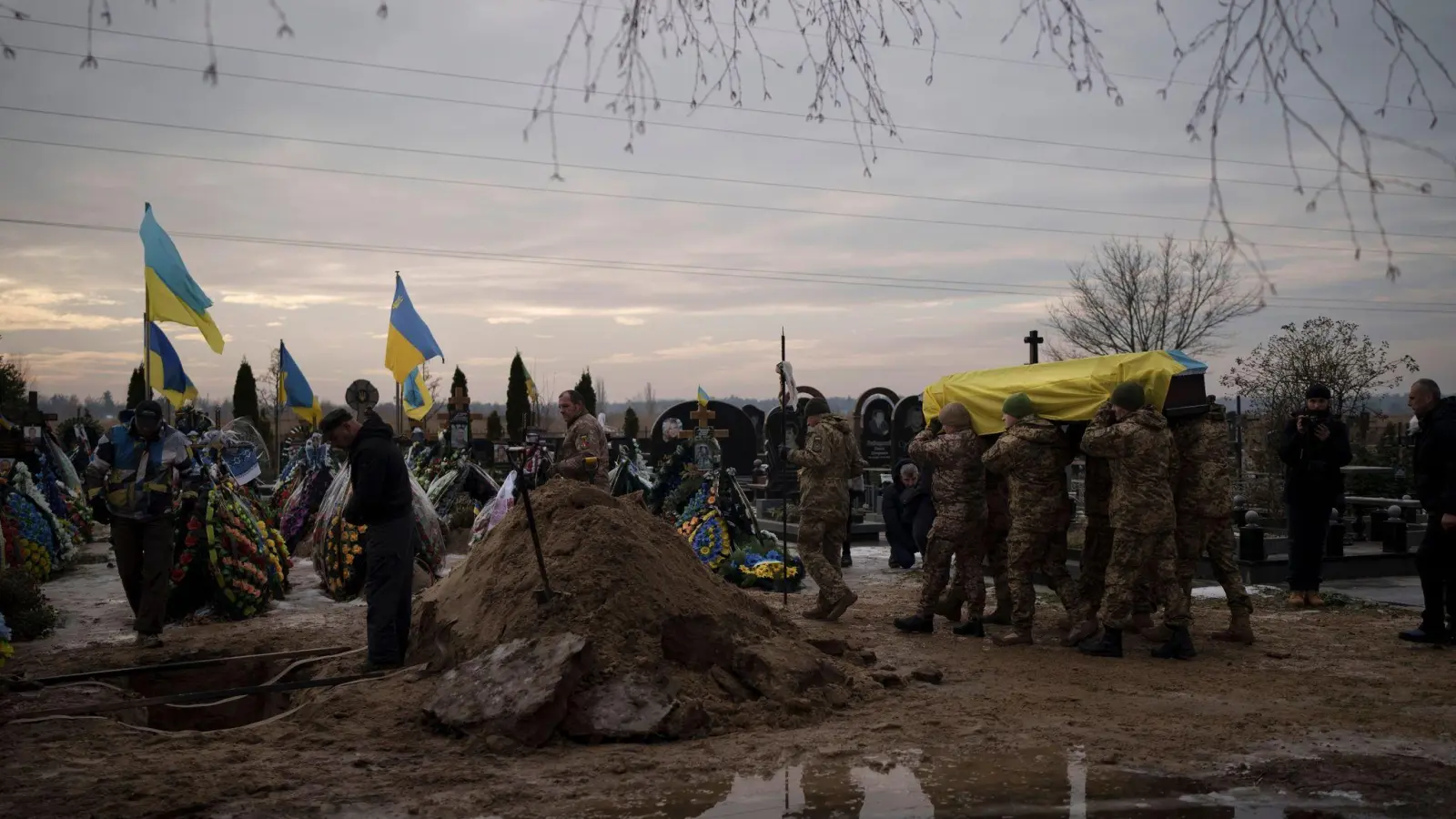 Ukrainische Soldaten tragen den Sarg eines 33-jährigen Kameraden während dessen Beerdigung in Butscha. Der Soldat starb während eines Kampfeinsatzes in der Region Donezk. (Foto: Felipe Dana/AP/dpa)
