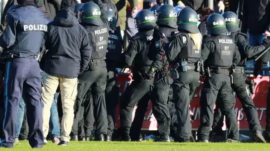 Polizisten stehen vor dem Bayern-Fanblock. (Foto: Mladen Lackovic/Mladen Lackovic/dpa/Archivbild)