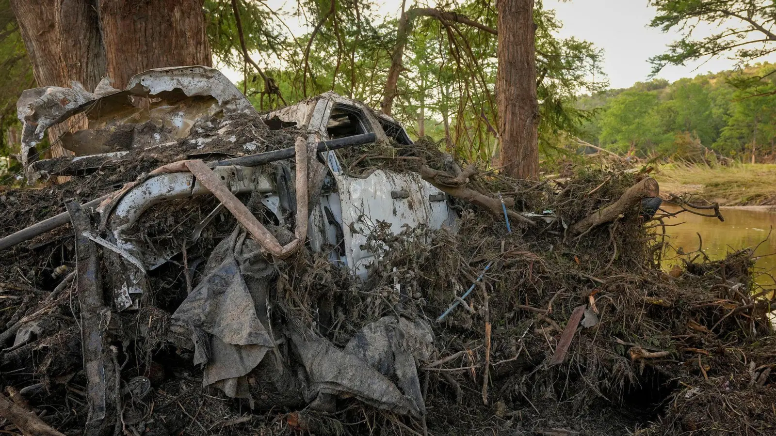 Ein Lastwagen ist am Ufer des Guadalupe River in Ingram, Texas, nach dem Hochwasser vom 4. Juli mit Trümmern bedeckt. (Foto: Jay Janner/Austin American-Statesman via AP/dpa)