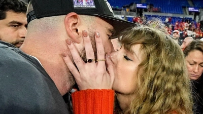 Ein Kuss für den AFC-Champion: Nach dem Sieg gegen die Baltimore Ravens holt sich Travis Kelce einen Kuss von Freundin Taylor Swift ab. (Foto: Julio Cortez/AP/dpa)