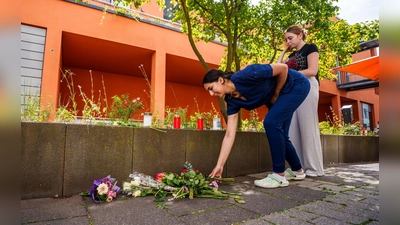 Menschen kommen vorbei und legen Blumen ab. (Foto: Andreas Arnold/dpa)