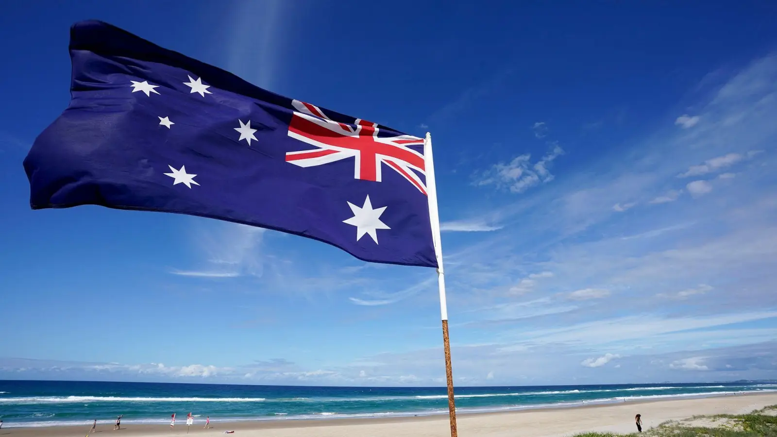 Die australische Flagge an einem Strand (Symbolbild). (Foto: Dave Hunt/AAP/dpa)