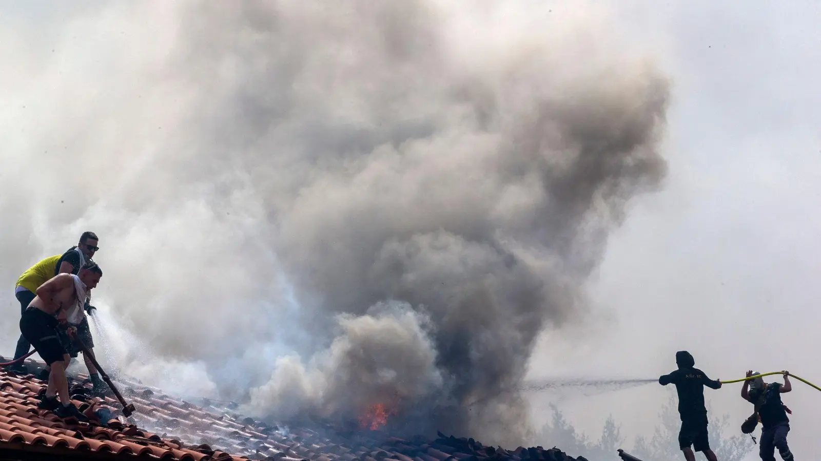 Freiwillige bekämpfen einen Waldbrand in der Nähe von Athen. (Foto: Marios Lolos/Xinhua/dpa)
