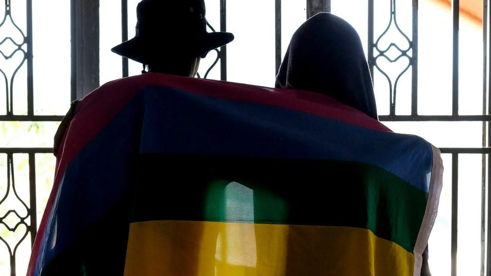 Ein Paar mit einer Pride-Fahne: Die rechtliche Situation offen queerer Menschen ist nicht nur in Uganda schwierig. (Foto: AP/dpa)
