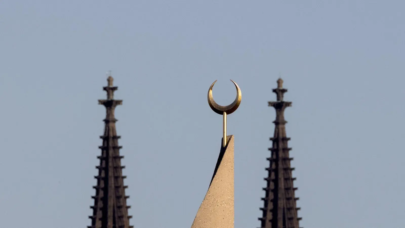 Der Halbmond auf einer Moschee ist zwischen den Türmen des Kölner Doms zu sehen. Der Auftritt eines hochrangigen afghanischen Taliban-Funktionärs in einer Kölner Moschee löst harsche Kritik aus. (Foto: Rolf Vennenbernd/dpa)