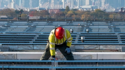 Elektriker installieren im New Yorker Stadtteil Queens Solarpaneele. Die US-Regierung hebt Zoll-Ausnahmen für bestimmte Solar-Importe auf. (Foto: Mary Altaffer/AP/dpa)