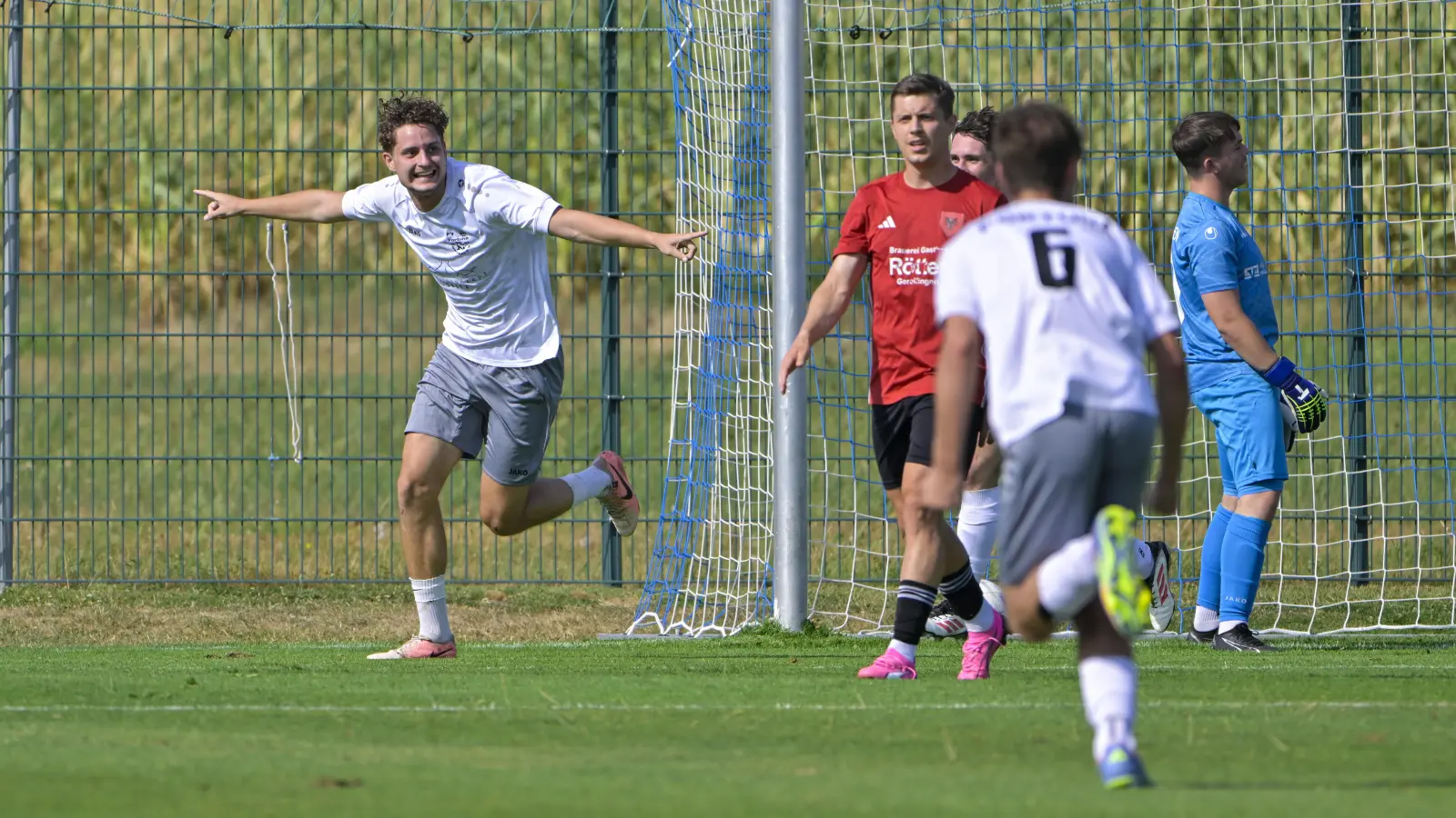 Jan Zimmermann (links) jubelt über das 1:0 für Fortuna Neuses (mit der Nummer 6 Felix Göttler) gegen den SC Aufkirchen (von links Daniel Holzmann und Torwart Philipp Weigel). (Foto: Martin Rügner)