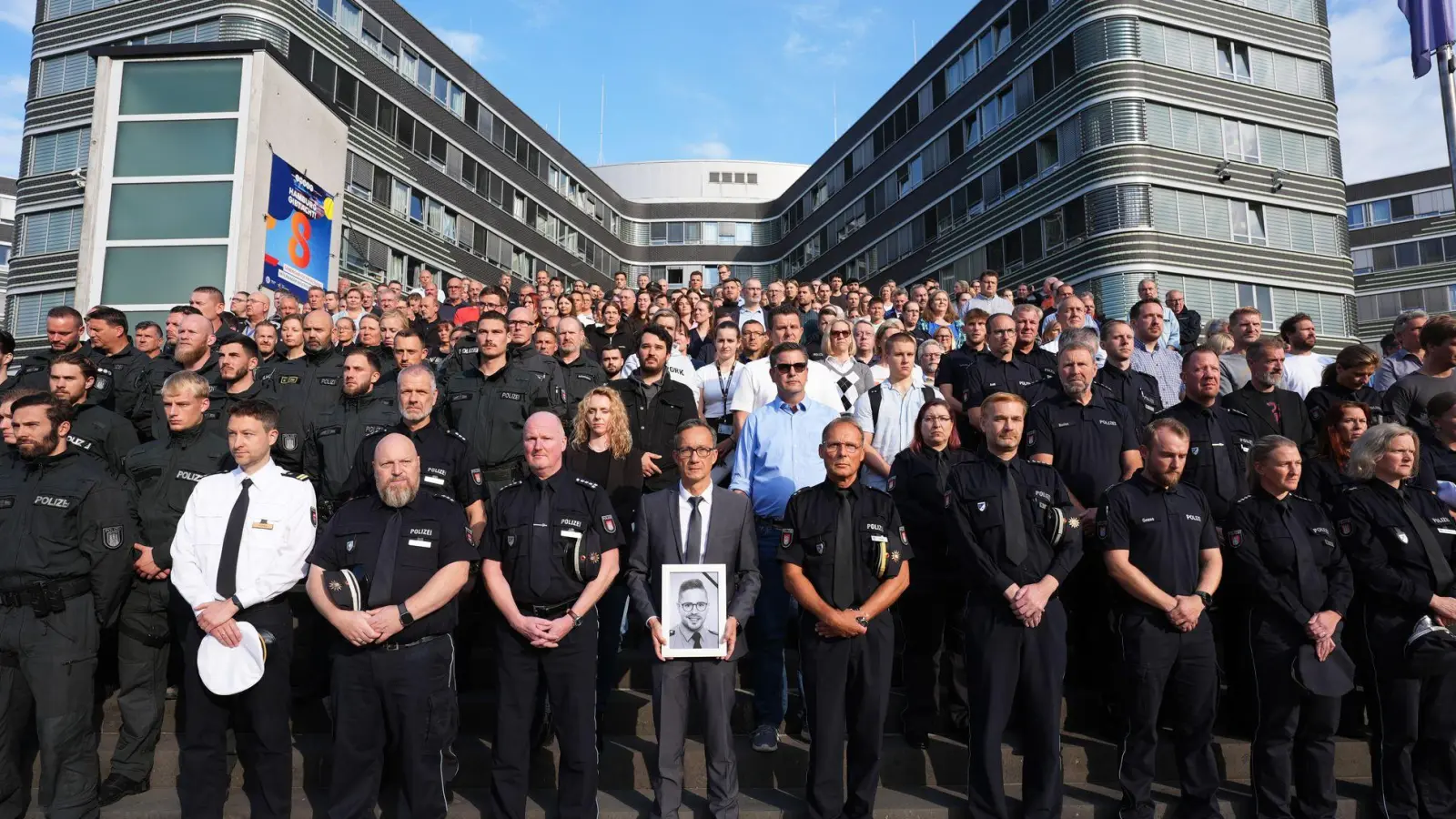 Das saarländische Innenministerium hatte die Polizeibehörden der anderen Länder und des Bundes eingeladen, sich der Gedenkminute anzuschließen. Hier zahlreiche Beamte vor dem Polizeipräsidium in Hamburg. (Foto: Marcus Brandt/dpa)