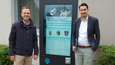 Diespecks Bürgermeister Dr. Christian von Dobschütz (links) und Kevin Dax, Geschäftsführer der P&amp;P-Digitalisierungs-GmbH, präsentieren das Touchscreen-Infoterminal am Sport- und Gemeindezentrum. (Foto: Christa Frühwald)