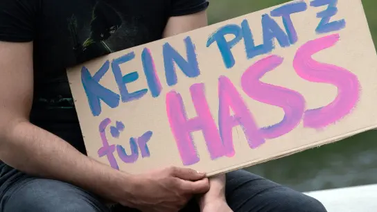 „Kein Platz für Hass“ steht auf dem Plakat eines Demonstranten auf einem Pappschild. (Foto: Paul Zinken/dpa/Symbolbild)