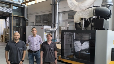 Petro Dikij (links) und Holger Vogel (rechts) haben die Firma Glacryl nach der Insolvenz übernommen. Der frühere Chef Wolfgang Hedel (Mitte) unterstützt sie. Hinter ihnen ist die moderne Maschine zu sehen, die Material in fünf Dimensionen bearbeiten kann.  (Foto: Thomas Schaller)