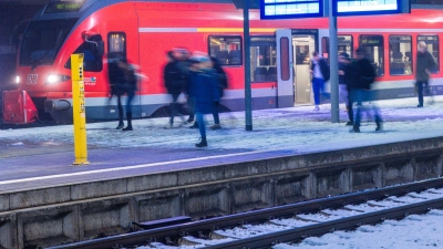 Fahrgäste warten auf einem Bahnsteig auf ihren Zug. (Symbolbild: Jens Büttner/dpa)