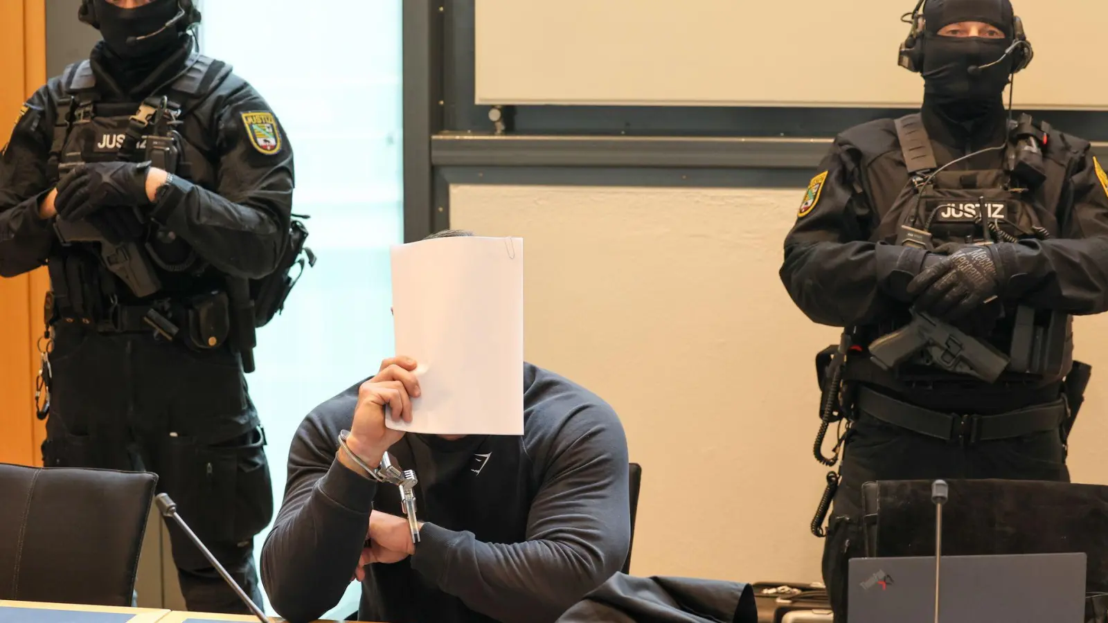 Der Angeklagte sitzt im Gerichtssaal des Landgerichts Magdeburg zwischen zwei Justizbeamten. (Foto: Peter Gercke/dpa)