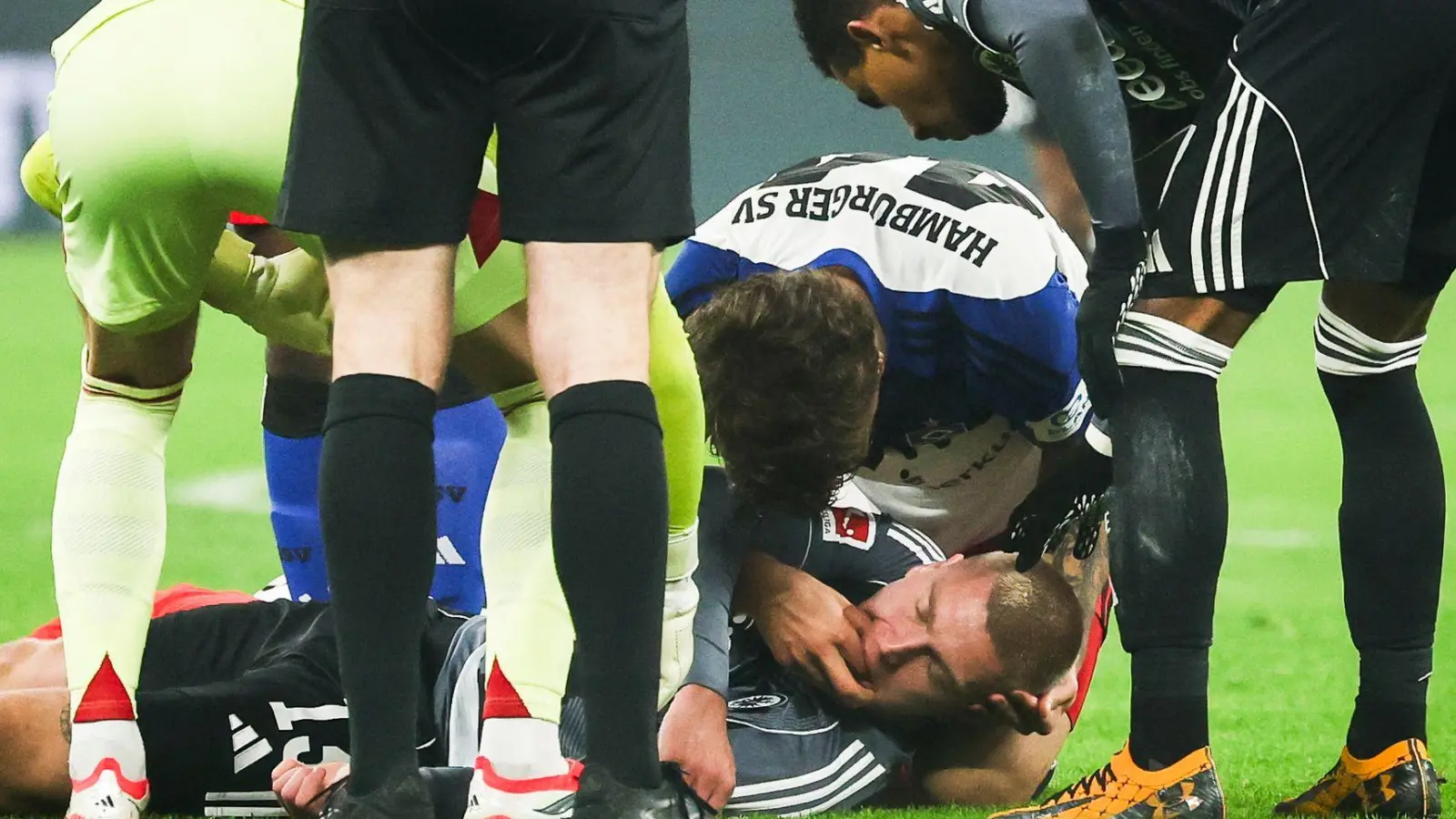 HSV-Verteidiger Luka Vuskovic hilft dem am Boden liegenden Eintracht-Profi Rasmus Kristensen.  (Foto: Christian Charisius/dpa)