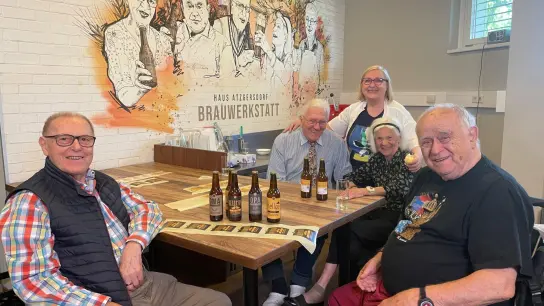 Auch das Etikettieren von Bier aus eigener Produktion zählt zu den Aufgaben im Altersheim. (Foto: Matthias Röder/dpa)