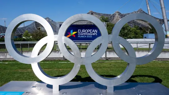 Die Olympischen Ringe und ein Plakat mit dem Logo der „European Championships 2022“. (Foto: Sven Hoppe/dpa/Symbolbild)