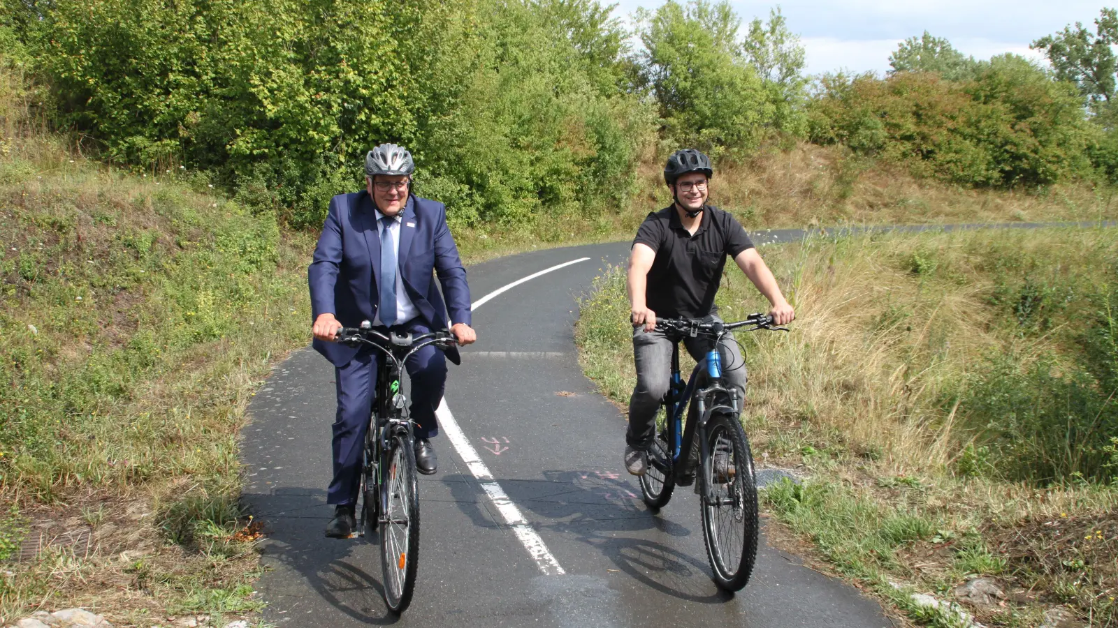 Zwei Männer, eine Fahrradseele: Landrat Helmut Weiß (links) und der Radverkehrsbeauftragte des Landkreises Sebastian Haser testen die Zählstelle, die mit Zeichen auf dem Asphalt gekennzeichnet ist. (Foto: Hans-Bernd Glanz)