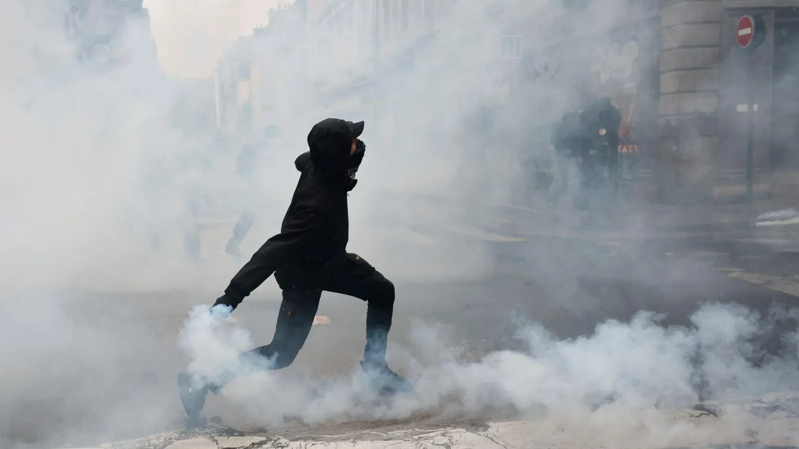 Ein Demonstrant wirft in Rennes eine Tränengasgranate in Richtung der Polizei. (Foto: Jeremias Gonzalez/AP/dpa)