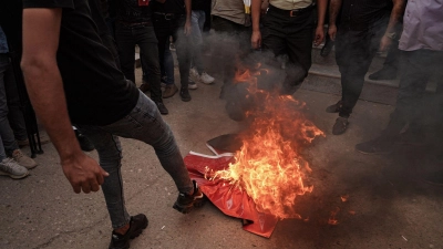 Deonstrierende treten vor dem Konsulat auf eine brennende türkische Flagge. (Foto: Ismael Adnan/dpa)
