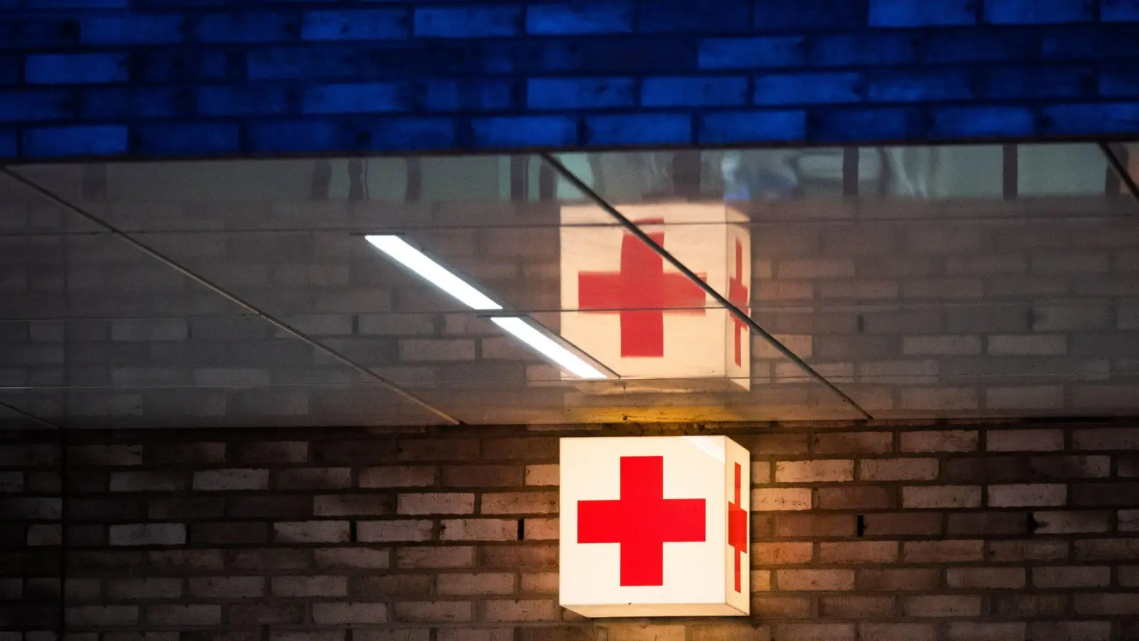 Ein Leuchtkasten mit einem roten Kreuz hängt vor der Notaufnahme eines Krankenhauses. (Foto: Julian Stratenschulte/dpa/Symbolbild)