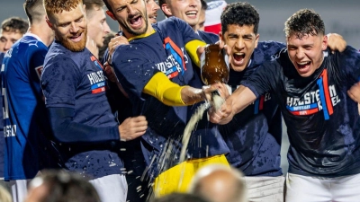 Die Spieler von Kiel feiern mit den Fans gemeinsam den Aufstieg. (Foto: Axel Heimken/dpa)