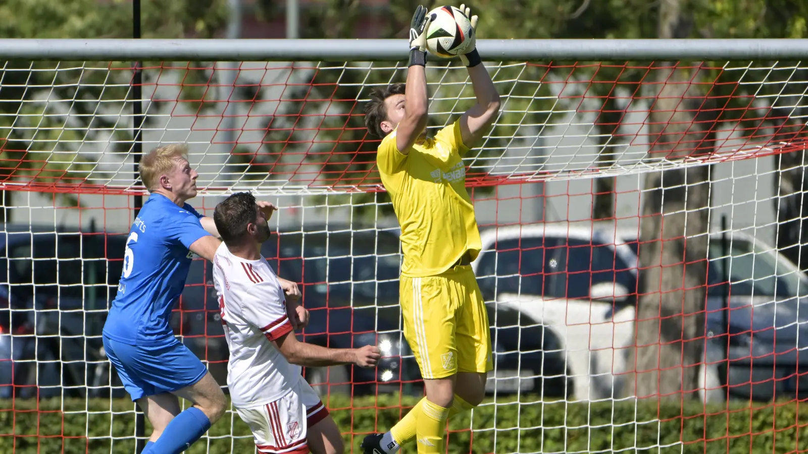 Abfangjäger: Torhüter Simon Einzinger war ein sicherer Rückhalt seines TSC Neuendettelsau (in Weiß Alexander Roth) im Spiel gegen Röslau (in Blau Matthias Dadder). (Foto: Martin Rügner)