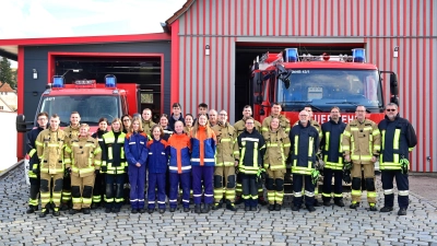 Allerlei fröhliche Blicke beim Fototermin: Eine ganze Reihe von jugendlichen und erwachsenen Feuerwehrleuten präsentiert sich vor ihrem Domizil im Ansbacher Ortsteil Hennenbach. (Foto: Alina Boger)