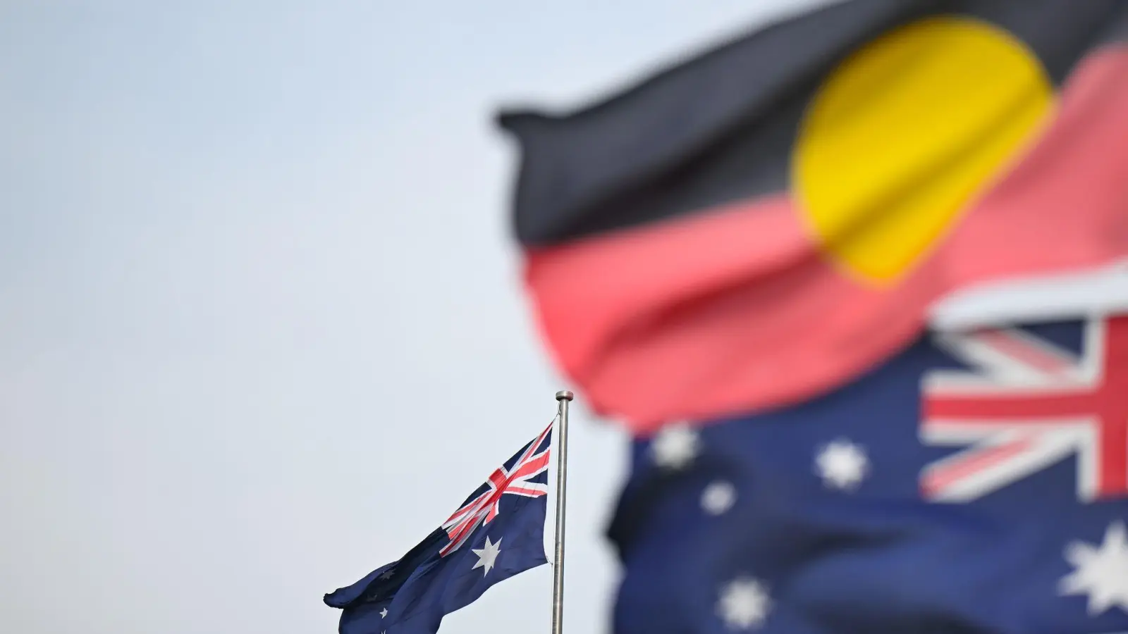 Zwei australische und eine Aborigine-Flagge wehen in Canberra. (Foto: Lukas Coch/AAP/dpa)
