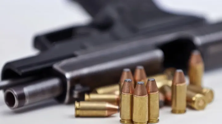 Eine Faustfeuerwaffe mit Magazin und Munition. (Foto: David Young/dpa/Symbolbild)