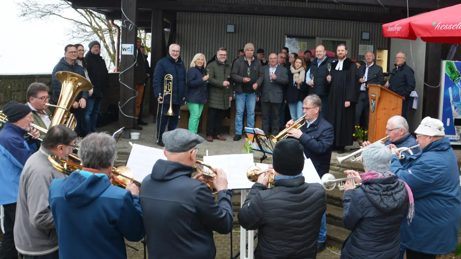 Stießen auf die Eröffnung des Kiosks am Hesselberggipfel an: MdL Helmut Schnotz, Edith Stumpf, stellvertretender Landrat Stefan Horndasch, Pächter Helmut Schuster, Bürgermeister Karl Fickel, Anuschka Hörr, Planer Christian Ertl und Pfarrer Simeon Prechtl (im Hintergrund, von links). (Foto: Peter Tippl)