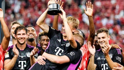 Frans Krätzig (M) hält den Pokal. Der FC Bayern reist im Sommer wieder nach Asien. (Foto: Danial Hakim/AP/dpa)